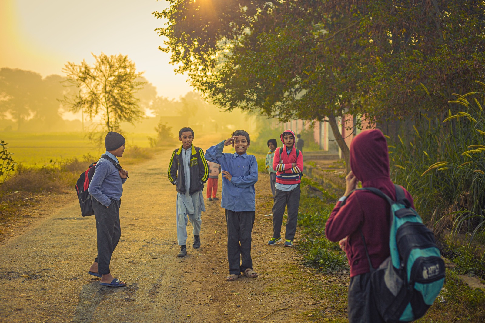 Children walking to school along a country road at sunrise